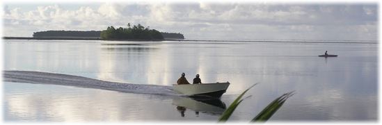 Boat and Canoe on Lagoon at Sunset